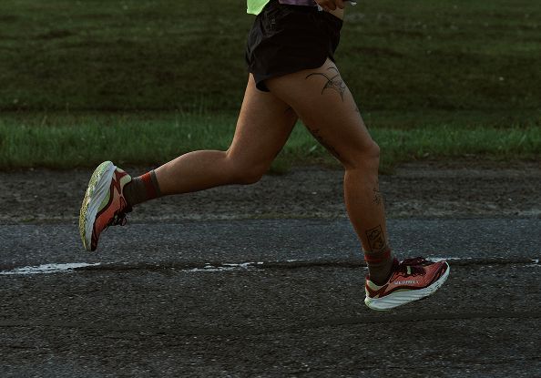 A woman running wearing Merrell shoes